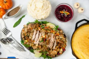 Apple Cider Turkey Breast sliced and spread out on a silver serving platter with stuffing makes a perfect small holiday entree.