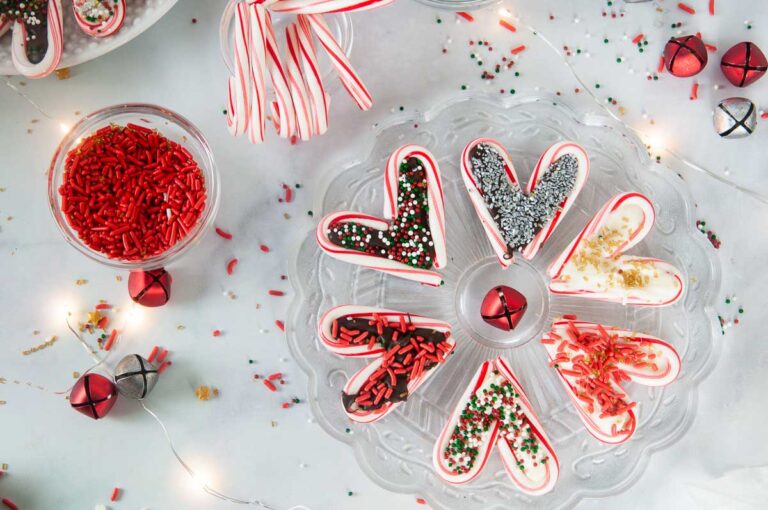 A festive spread featuring easy candy cane hearts on a white counter with sprinkles and candy canes