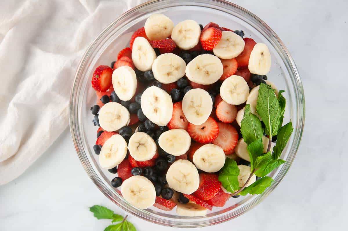 Add the sliced, cleaned fruit to a large bowl.