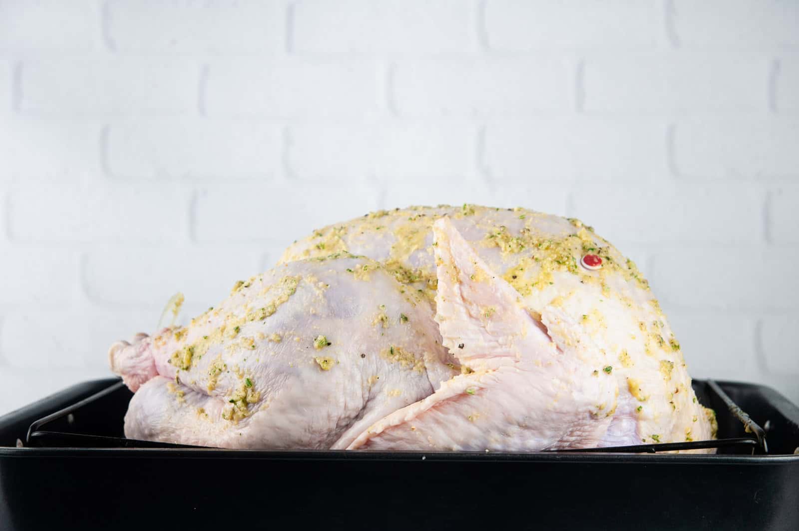 Slather the turkey in garlic butter, making sure to rub it into and under the skin.