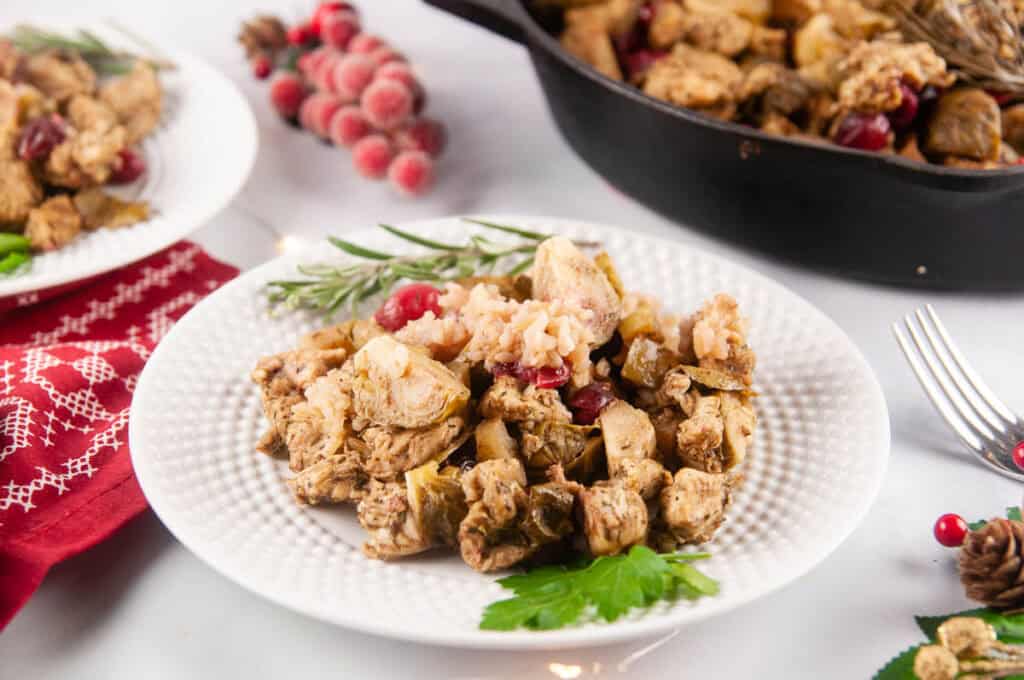 Cranberry Chicken is a festive, one skillet meal featuring tender chicken, juicy apples, Brussels sprouts, tart cranberries, and rice in a tangy sweet marinade.