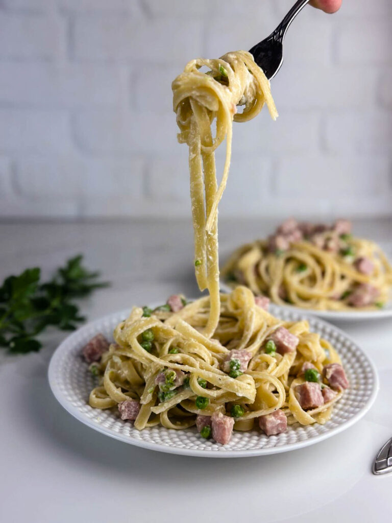 A plate of pasta with ham and peas makes delicious use of leftover ham in a hearty Italian inspired dinner.