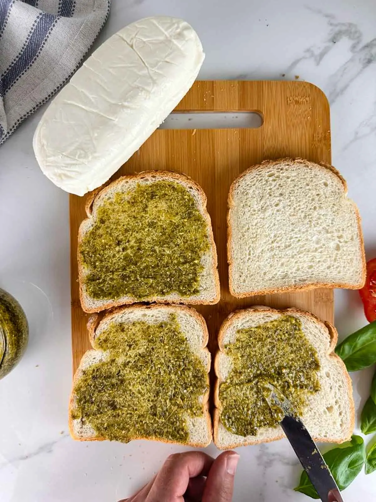 Spread one side of each slice of bread with pesto.