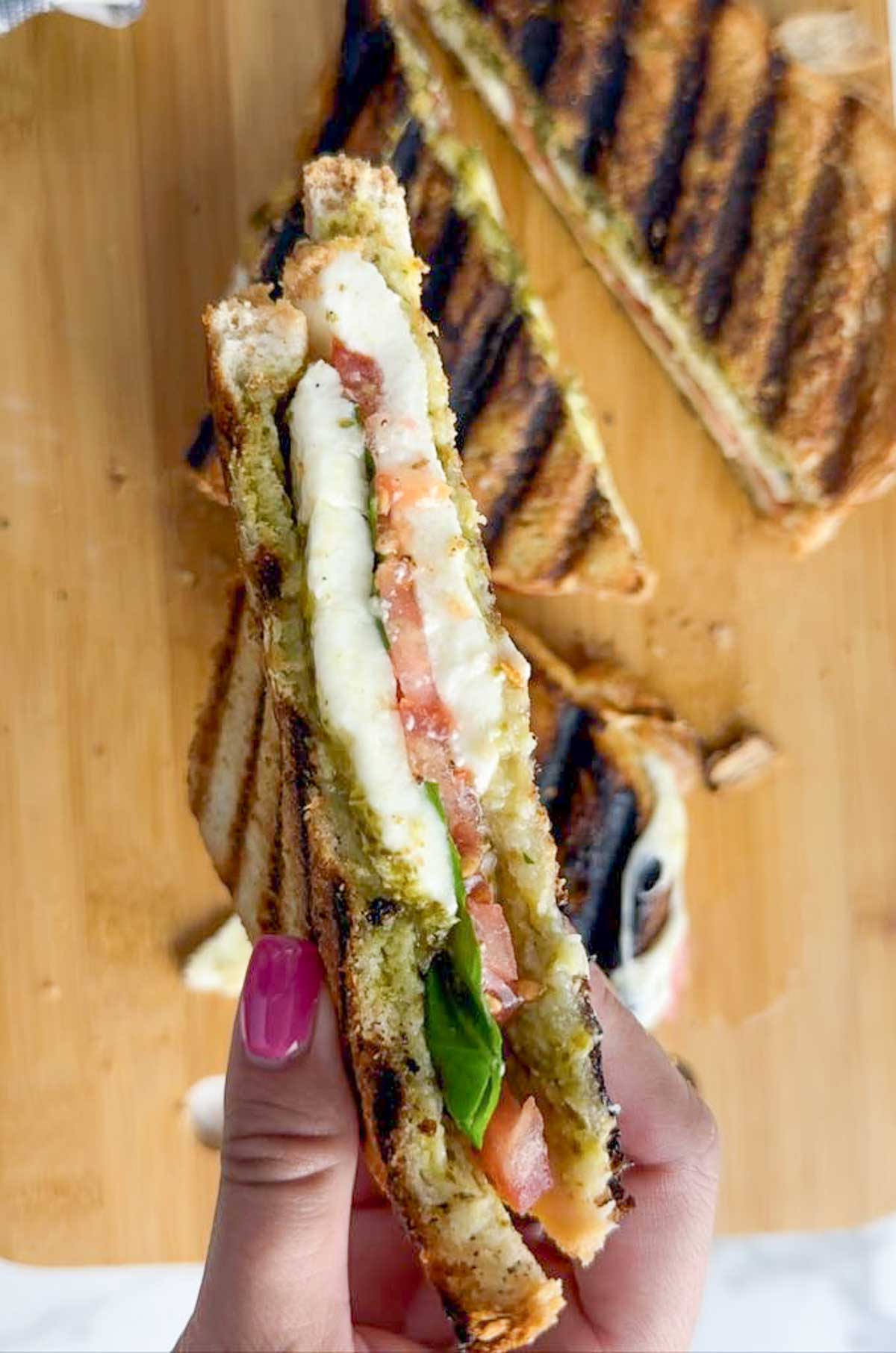This caprese panini sandwich with pesto features ooey, gooey mozzarella cheese, sweet tomato slices, fragrant basil, and bright herby pesto pressed between two slices of golden brown bread. The perfect easy lunch or dinner!