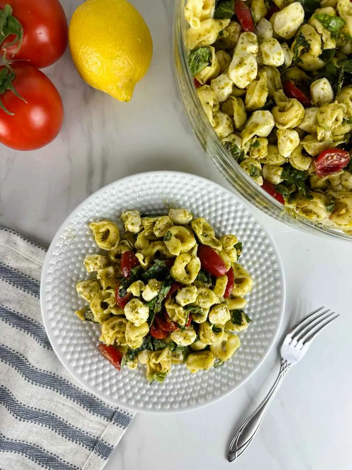 Caprese tortellini pasta salad with pesto is a fresh take on pesto pasta salad. Pillowy cheese tortellini gets tossed with lemon pesto, sweet cherry tomatoes, fragrant basil, and creamy mozzarella for a delicious cold pasta dish you'll love!