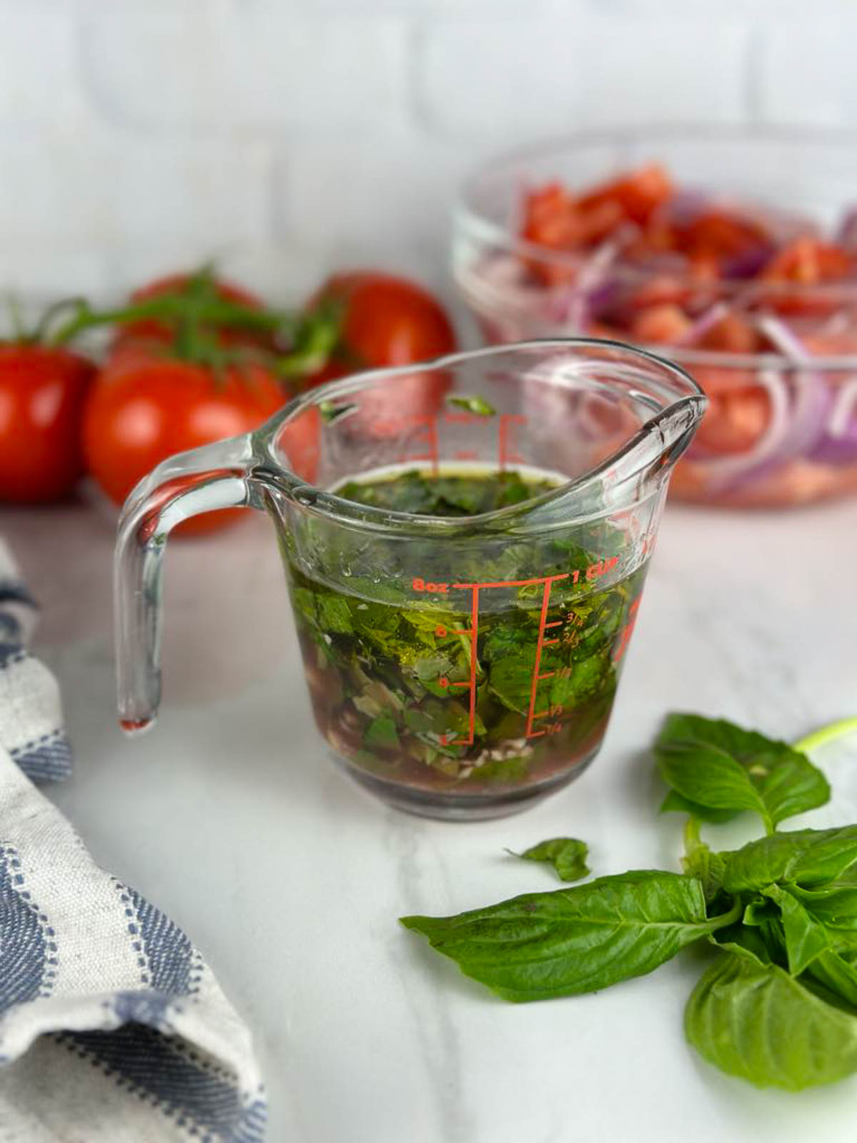 Whisk the olive oil, vinegar, garlic, and basil together to make dressing for the tomato onion salad.
