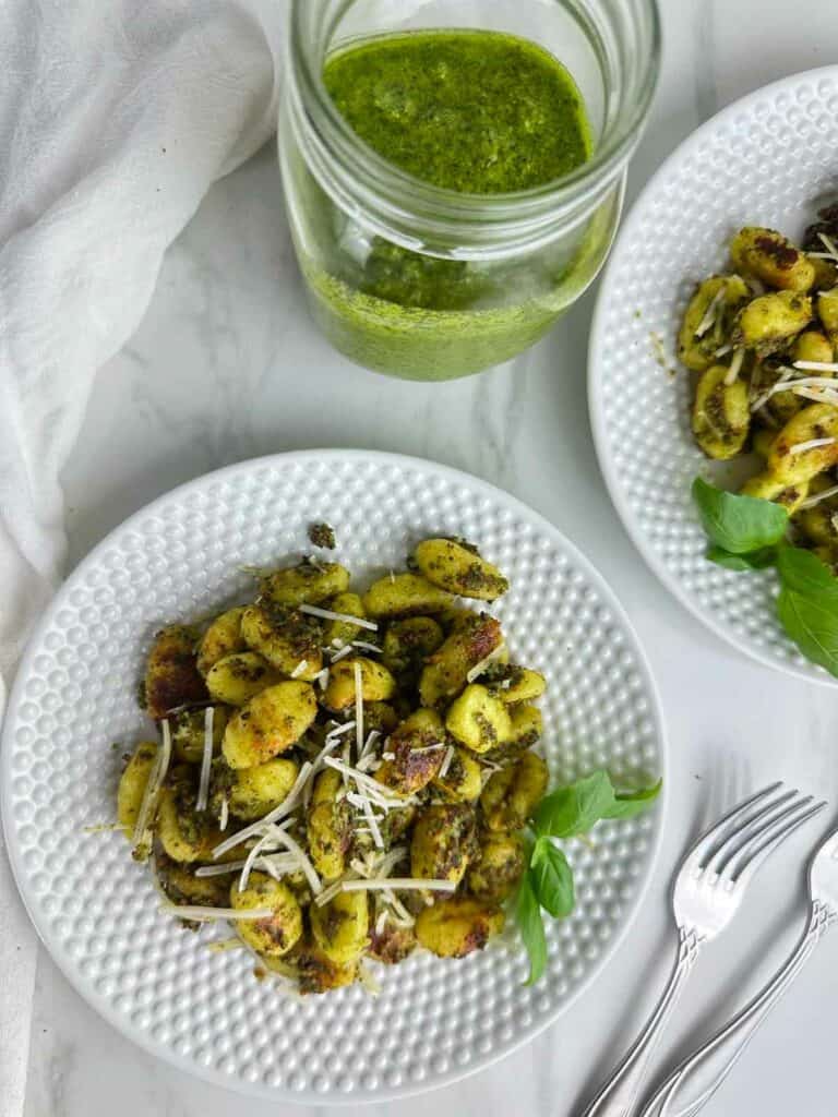 Baked gnocchi with pesto sauce features the Italian dumplings baked to crunchy perfection on a sheet pan before being tossed with fragrant pesto. Gnocchi and pesto sauce is an easy dinner any time.