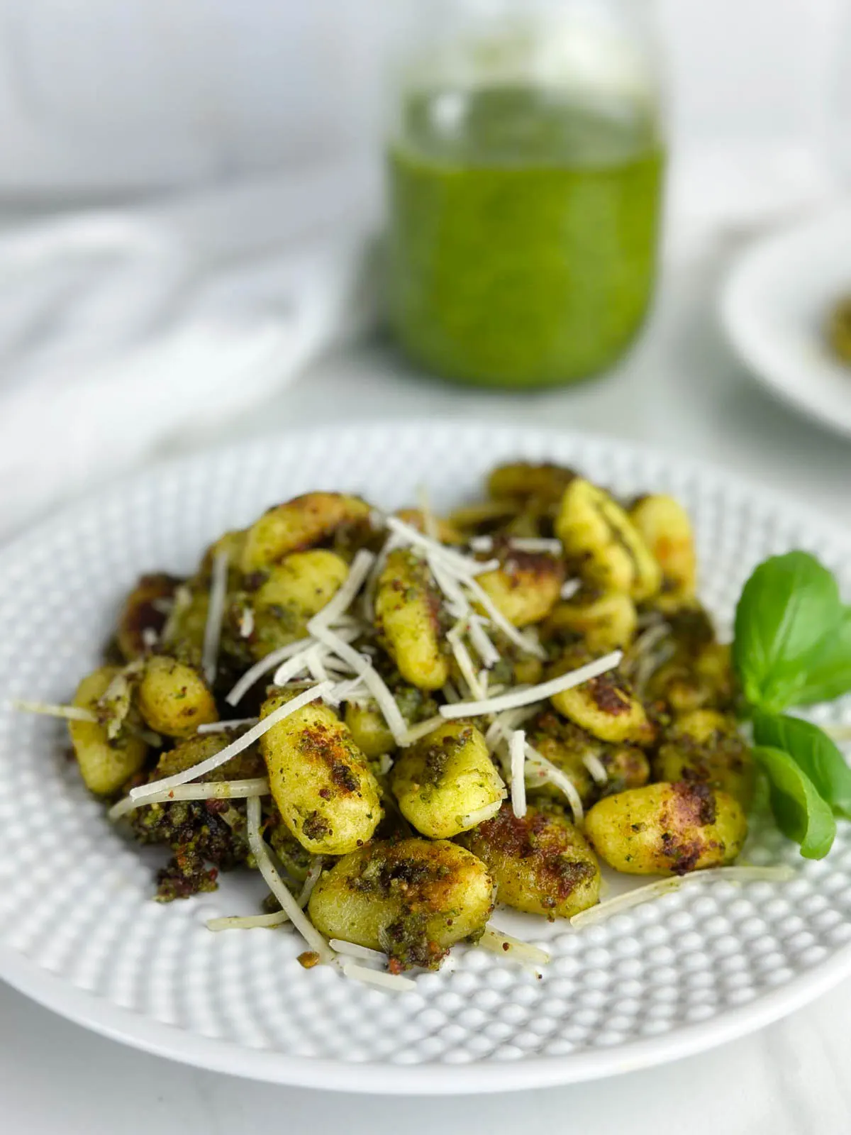 Baked gnocchi with pesto sauce features the Italian dumplings baked to crunchy perfection on a sheet pan before being tossed with fragrant pesto. Gnocchi and pesto sauce is an easy dinner any time.