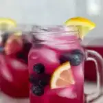 a photo of 2 glasses of blueberry vodka lemonade cocktails garnished with lemon wedges, blueberries, and mint in a text box reading blueberry lemonade cocktails