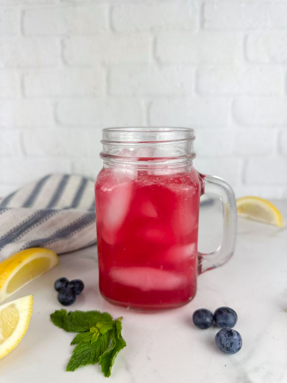 A mason jar mug full of blueberry lemonade