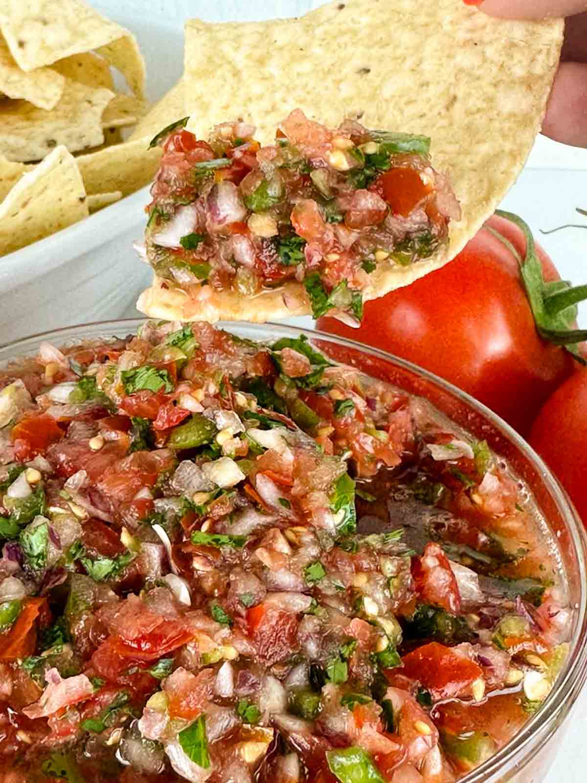 A chip dunked into fresh tomato salsa