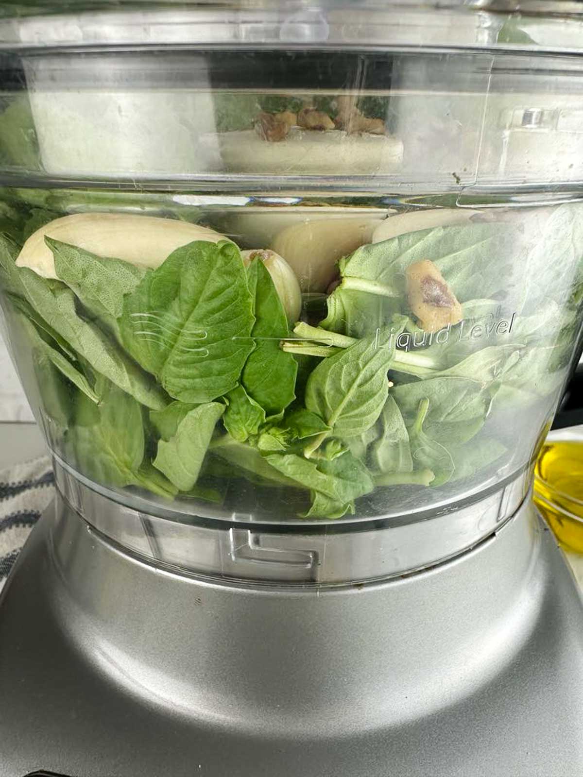 Add all the ingredients for the lemon pesto recipe into the food processor except for olive oil and lemon juice.