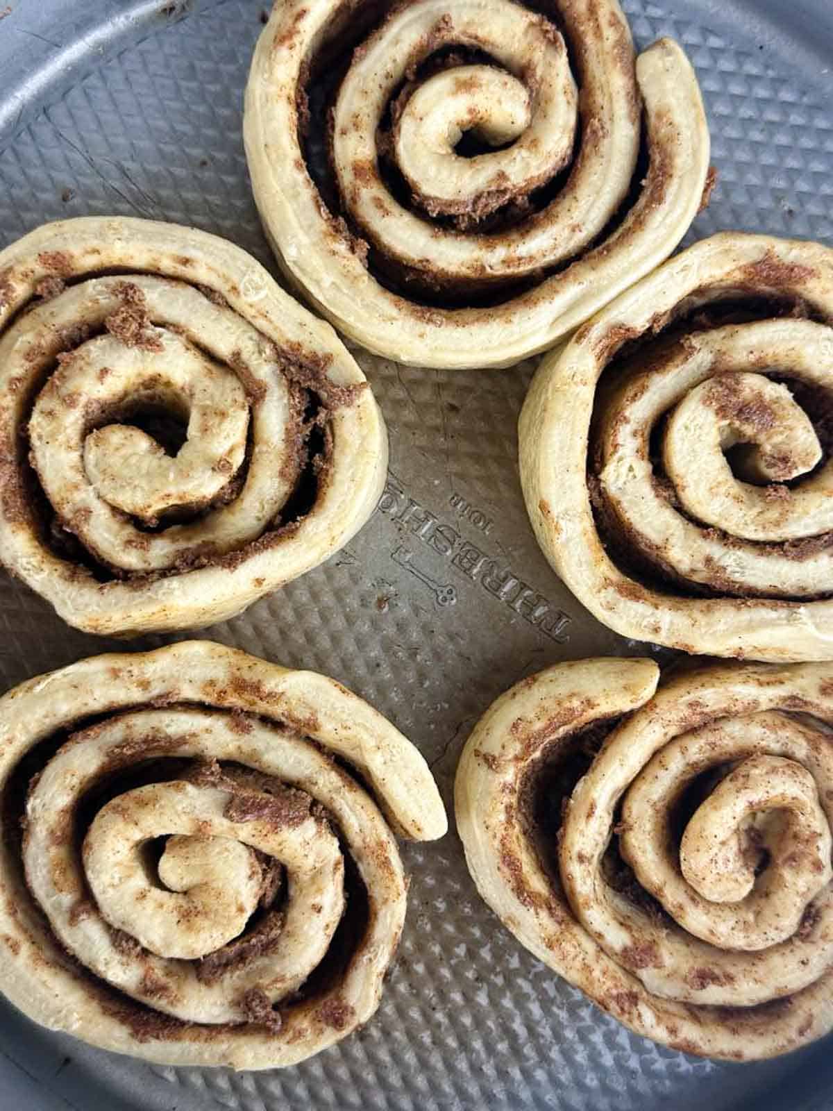 Put the rolls into a pie dish or baking dish, pulling them apart so there's room for you to stuff the apples in.