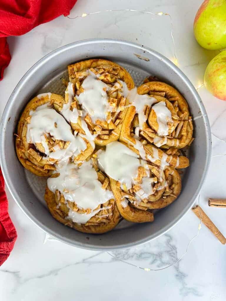 Drizzle the icing onto the apple pie cinnamon rolls