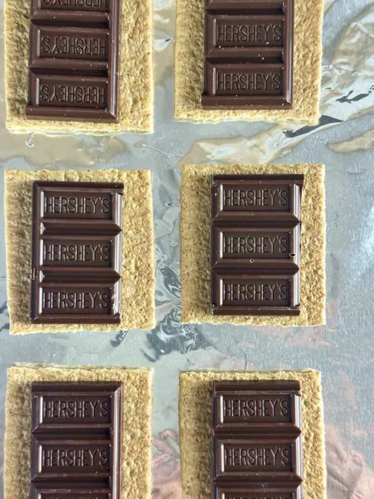 Arrange the chocolate bars in the center of each graham cracker