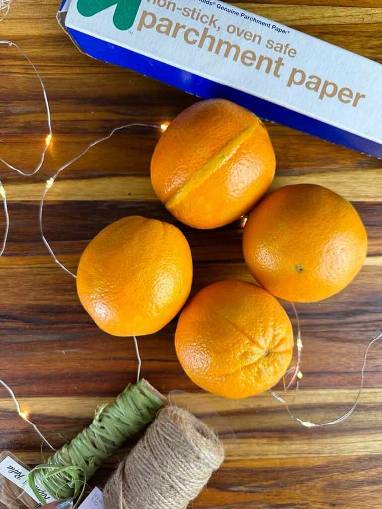 Materials to make oven dried orange slice ornaments: Oranges, parchment paper, and twine