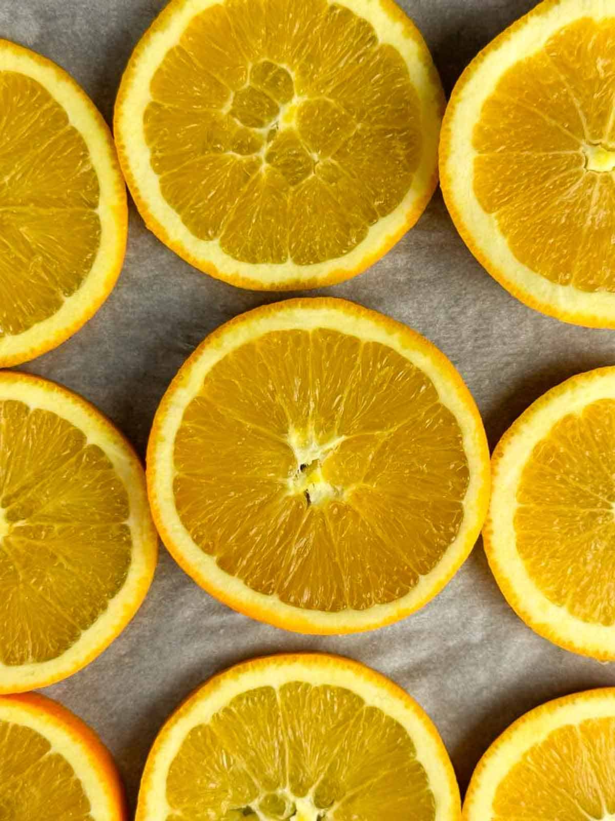 Oranges sliced on parchment paper ready to dry