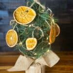 A mini Christmas tree decorated with dried orange slices on a kitchen counter