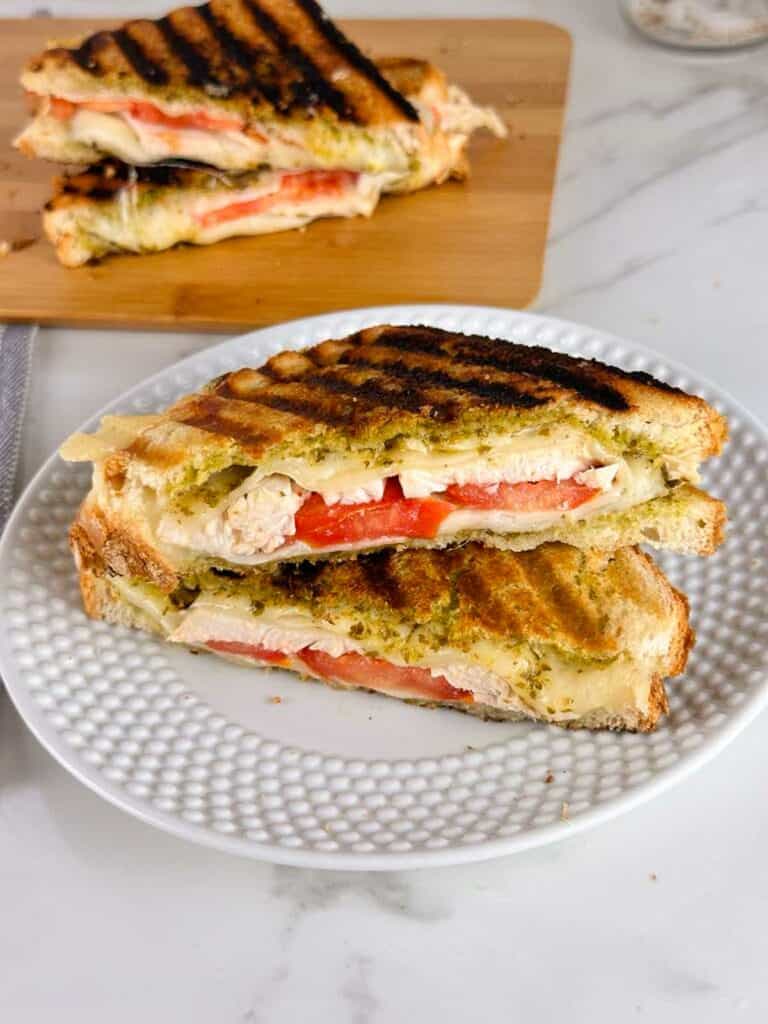 Turkey pesto paninis cut in half on a plate