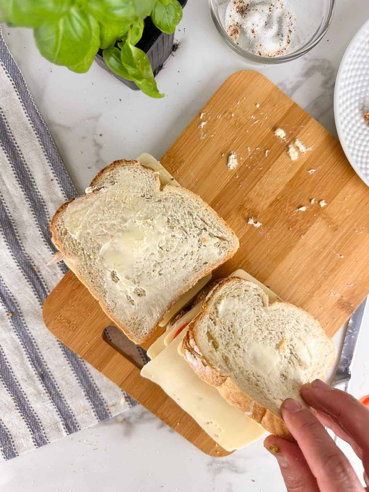 Close the turkey pesto panini with the second piece of pesto coved bread with the pesto side down and buttered side out.