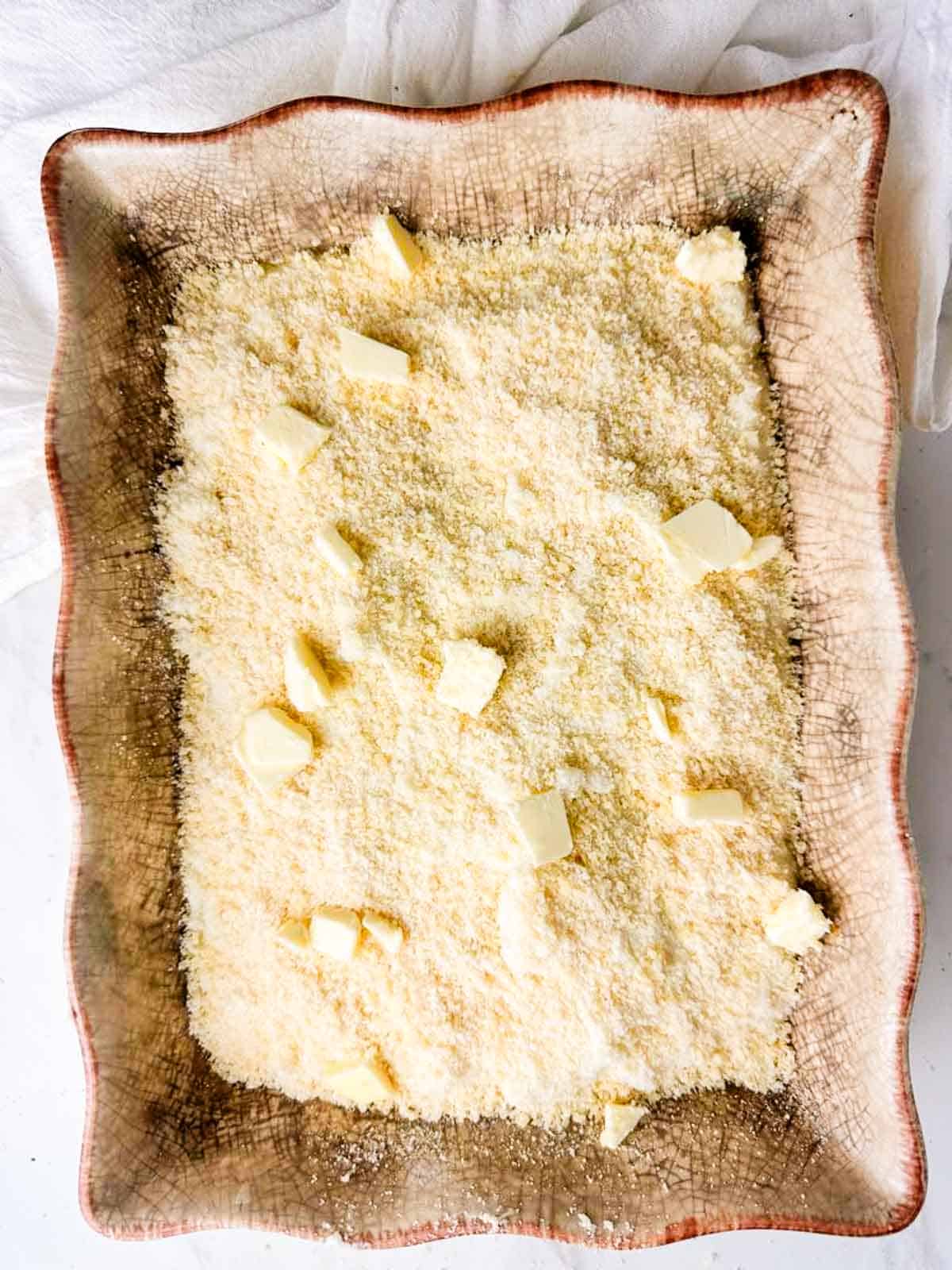 Top the twice baked potato casserole with more parmesan cheese and butter before baking