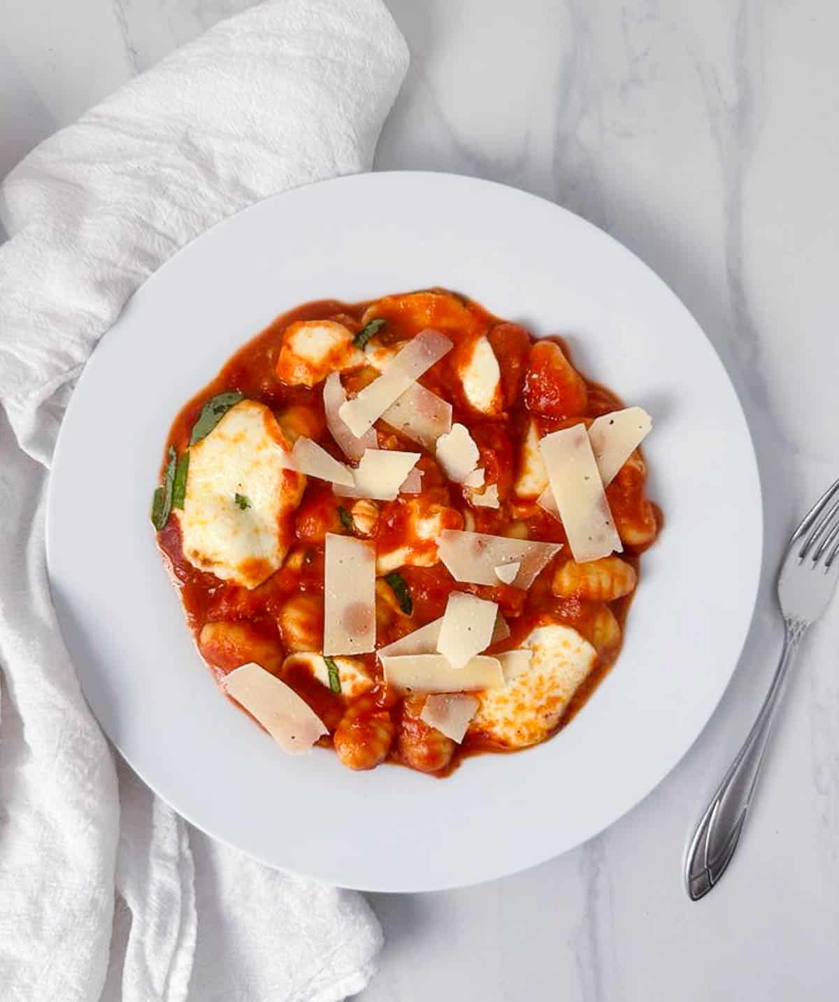 Serving of gnocchi alla Sorrentina with fresh parmesan on top.