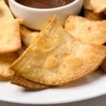 Homemade corn tortilla chip with coarse salt and a dipping sauce.