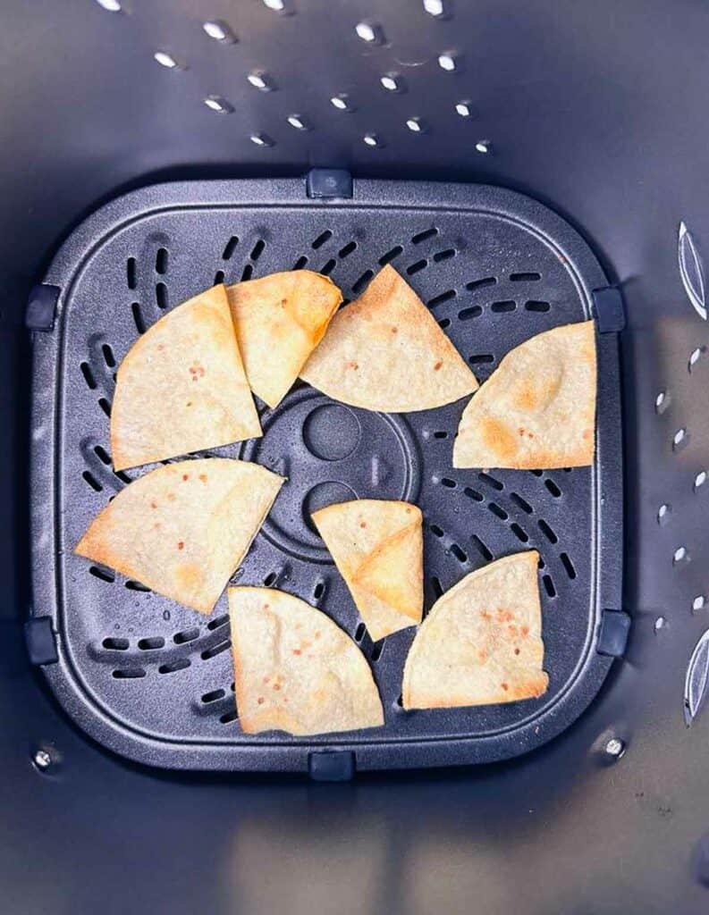 Air fryer homemade corn tortilla chips in air fryer basket.