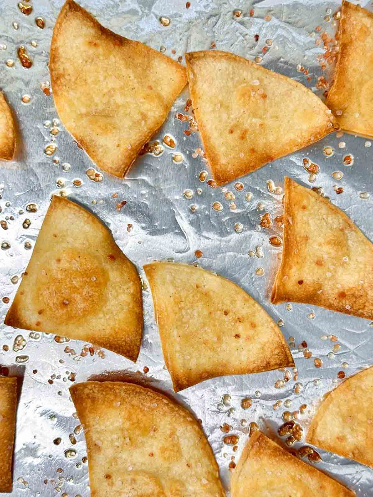 Golden brown corn tortilla chips coming out of the oven.