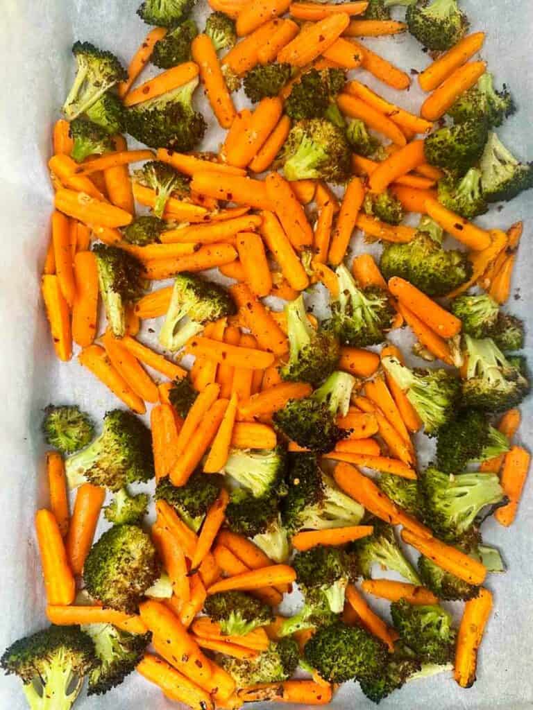 Tray of roasted broccoli and carrots after coming out of the oven.