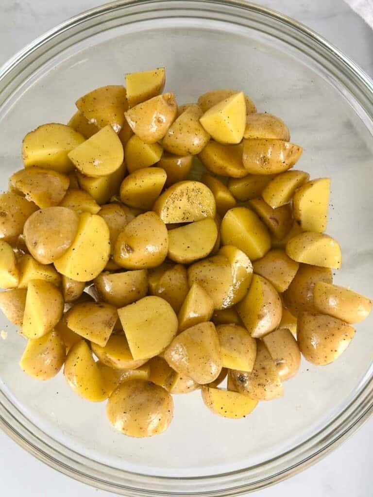 Quartered baby golden potatoes tossed with olive oil, salt, pepper, and garlic.
