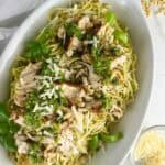 A serving platter full of chicken spaghetti pesto