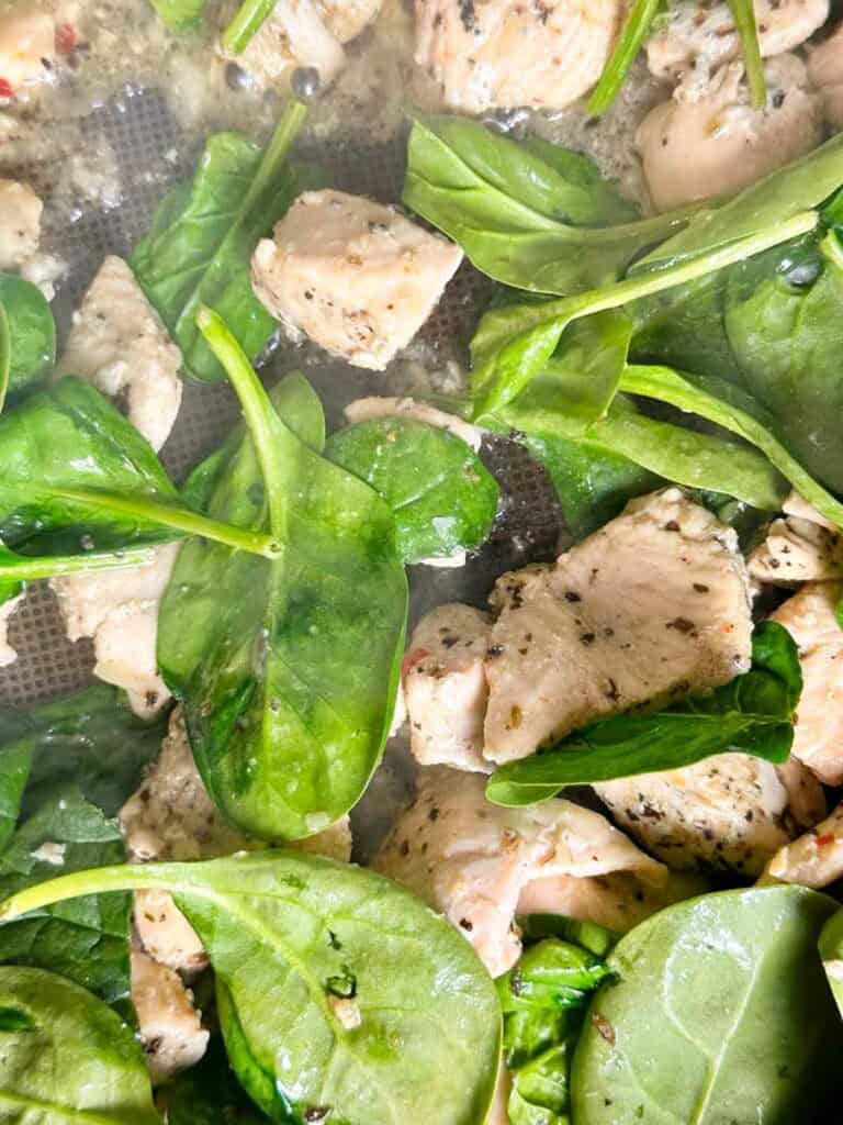 Spinach in a saute pan with chicken for Marry Me chicken pasta