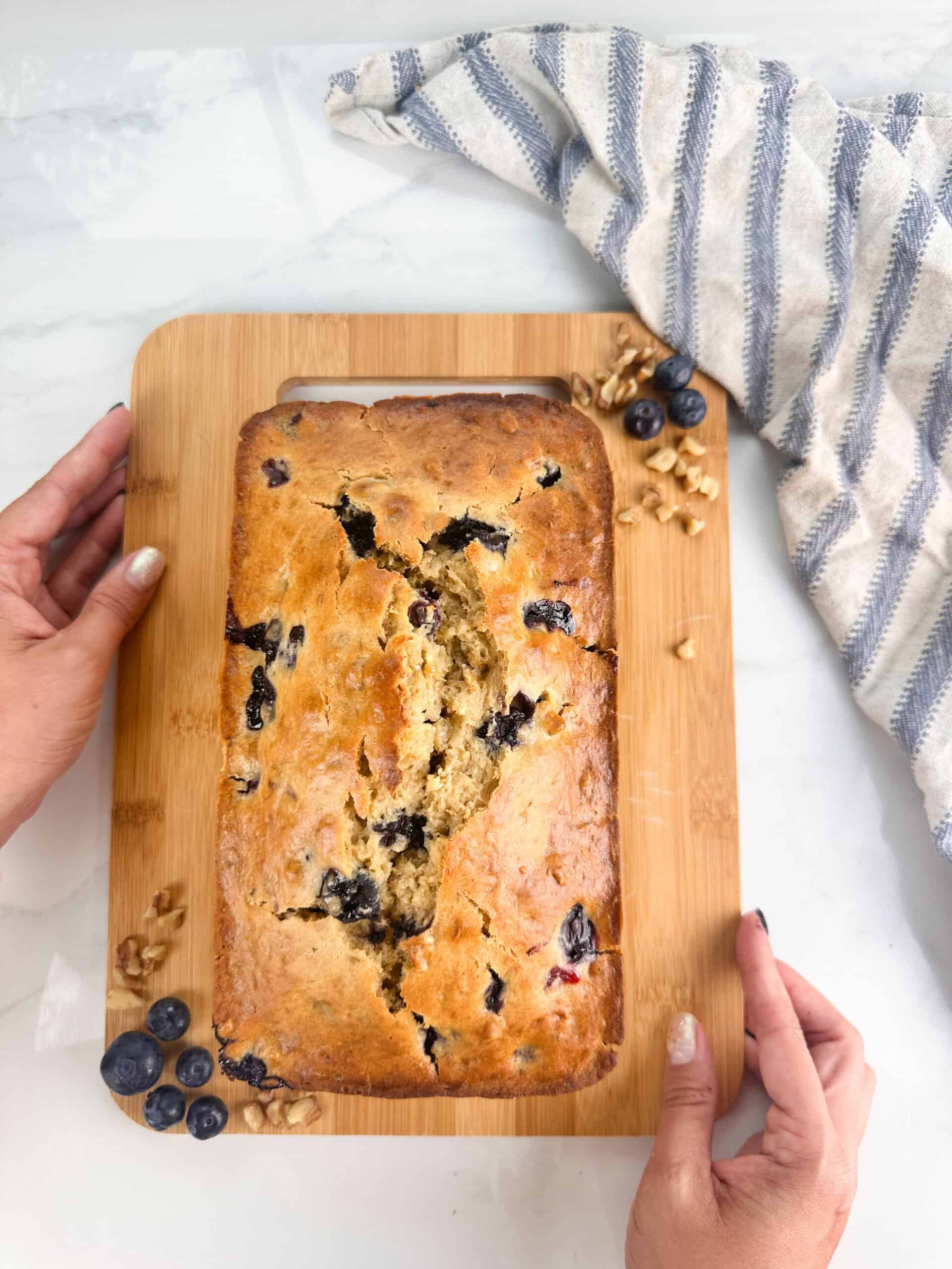 Blueberry banana nut bread on a wood cutting board