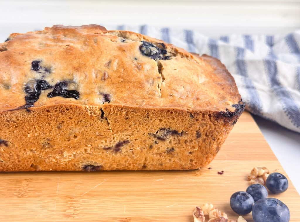 Blueberry banana nut bread on a wood cutting board