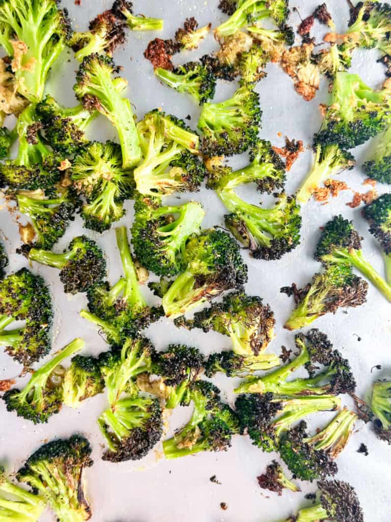 Broccoli and garlic on a baking sheet after baking.