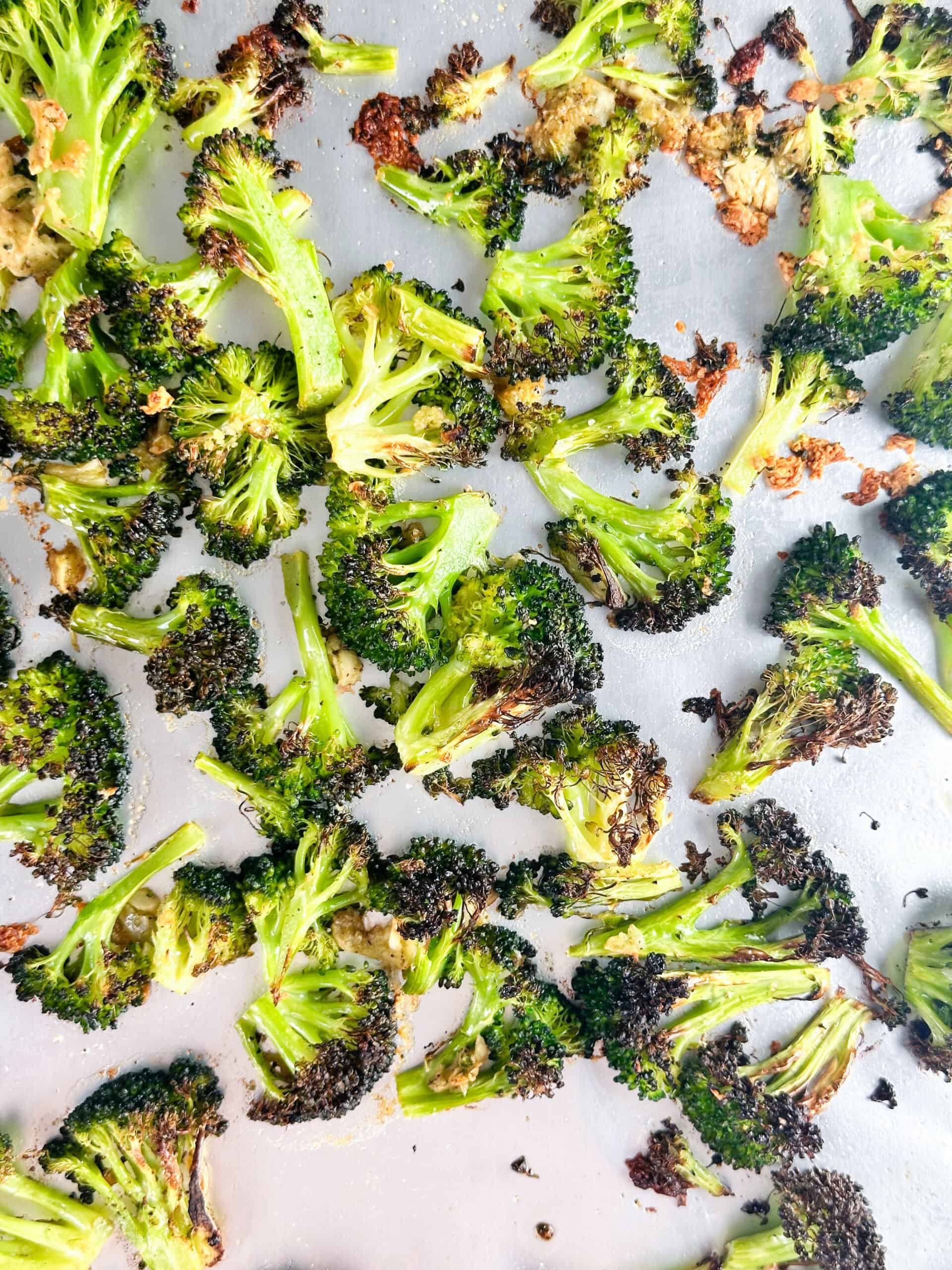 Broccoli and garlic on a baking sheet after baking.