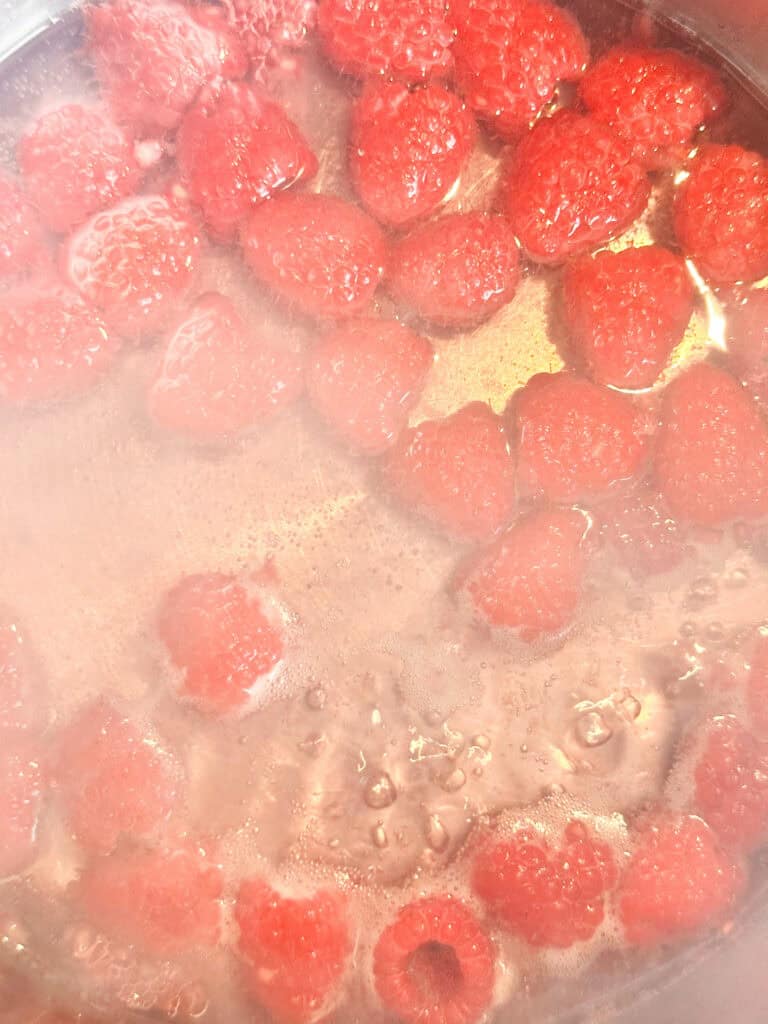 Raspberries simmering gently in simple syrup.