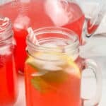 A photo of two glasses of raspberry lemonade and a pitcher of raspberry lemonade set inside text that reads raspberry lemonade seasonedsprinkles.com
