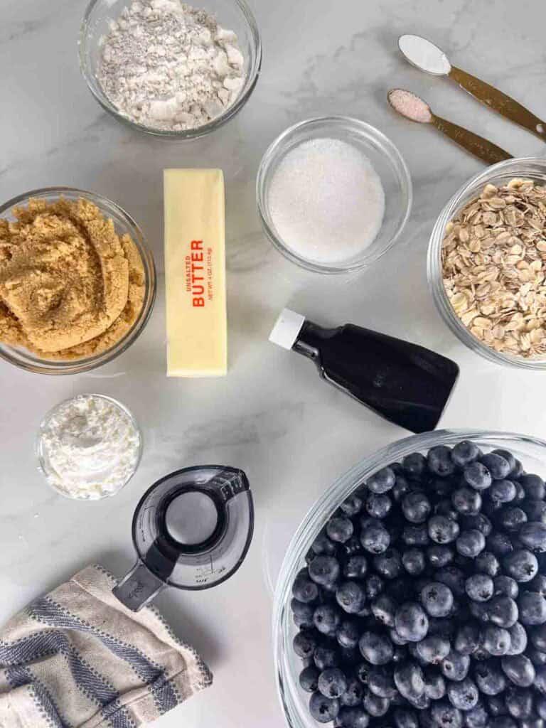 Blueberry crumble ingredients: flour, sugar, baking powder, salt, brown sugar, butter, vanilla extract, oats, corn starch, water, and blueberries.