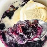 Spoon of blueberry crumble with ice cream and more below.