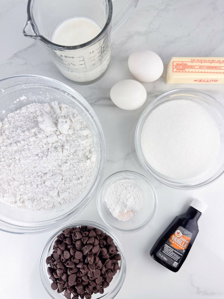 Ingredients for buttermilk chocolate chip muffins: buttermilk, eggs, butter, flour, sugar, baking powder, salt, chocolate chips, and vanilla extract.