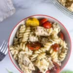 Ready to eat chicken pesto pasta salad in a small bowl.