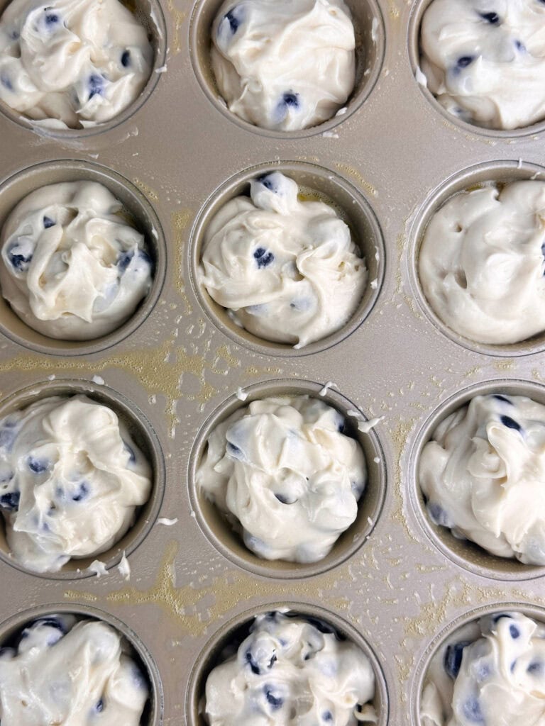 Buttermilk blueberry muffins batter doled out into muffin cups.