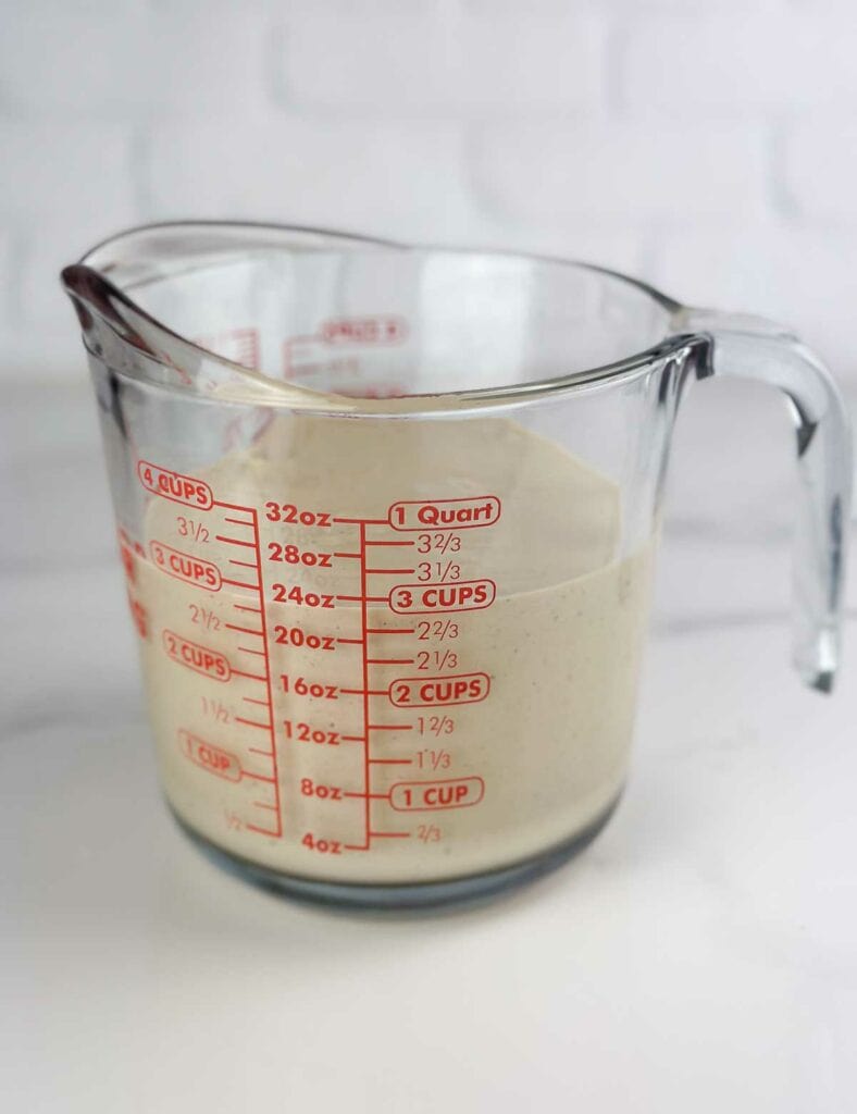 Measuring cup showing 3 cups of a homemade Caesar salad dressing witout anchovies.