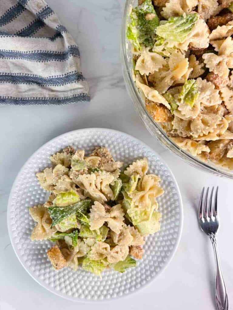 Fully mixed chicken Caesar pasta salad on a plate.