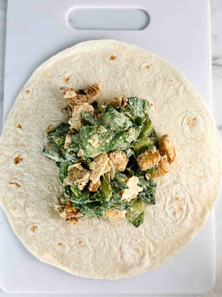 Chicken caesar salad placed in the center of the wrap.