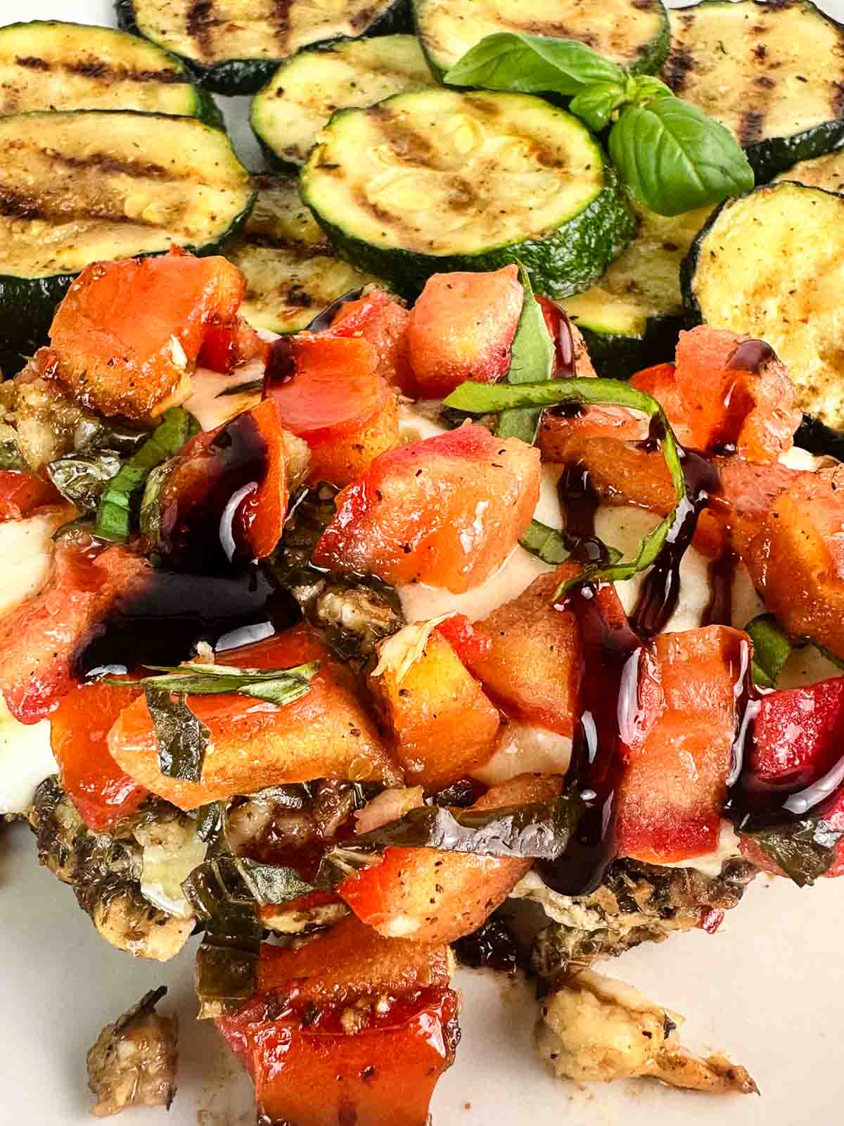 Drizzle of balsamic glaze over grilled bruschetta chicken