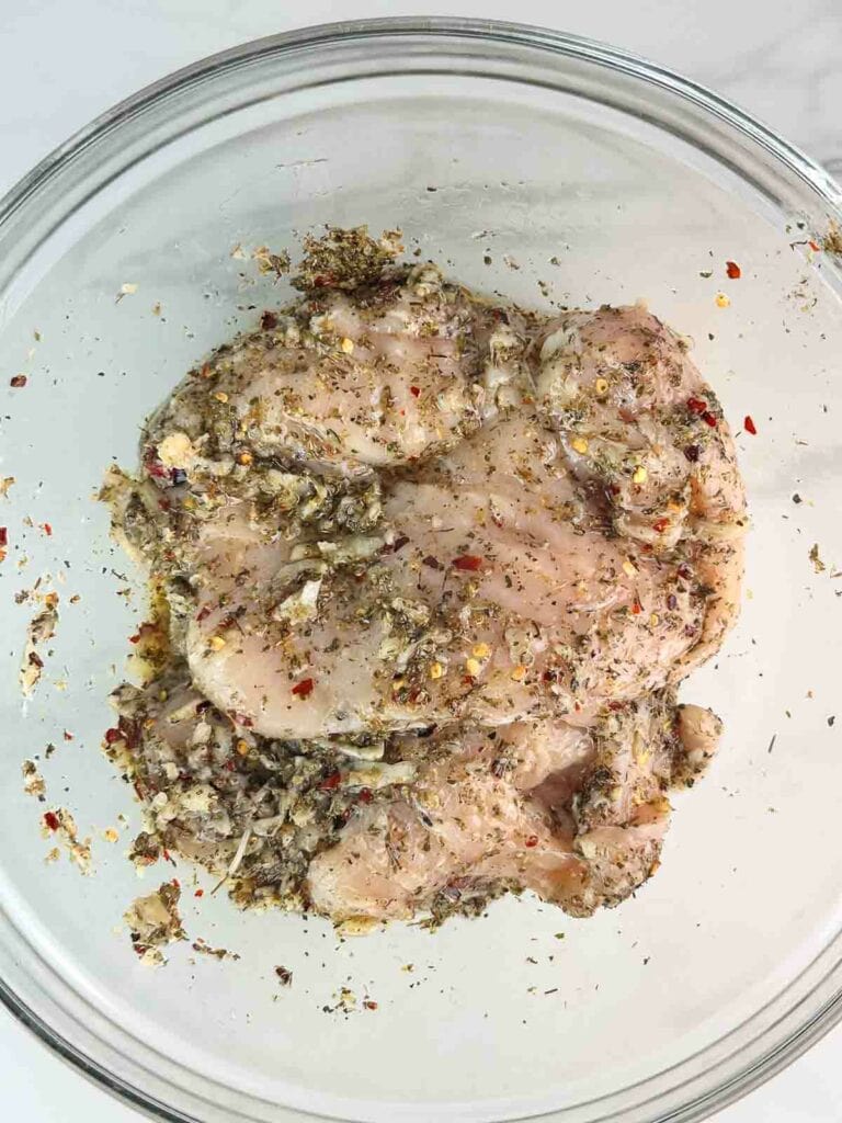 Chicken breasts tossed with seasoning.