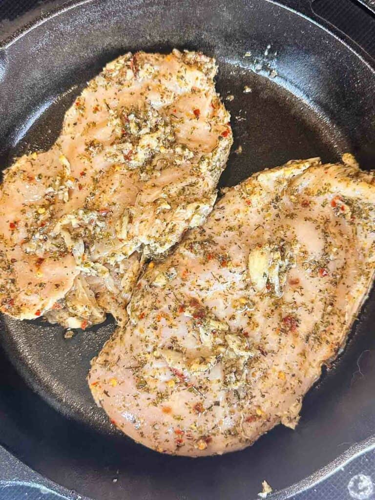 Cooking chicken in cast iron skillet.